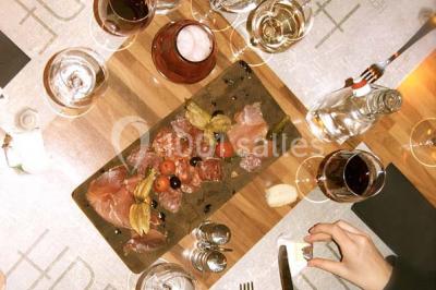 Salle sombre avec éclairage violet, plafond métallique, tables et chaises dispersées sur un sol à carreaux.