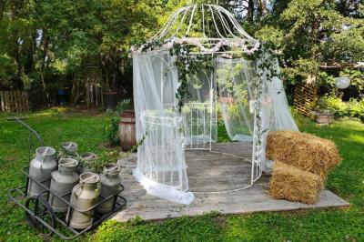 Salle sombre avec éclairage violet, plafond métallique, tables et chaises dispersées sur un sol à carreaux.