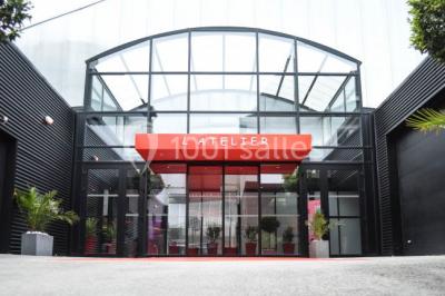 Salle de projection avec des rangées de sièges rouges, un écran noir et un plafond équipé de luminaires.