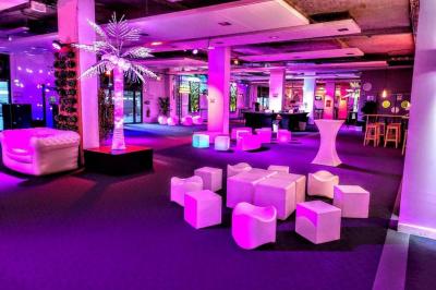 Salle de projection avec des rangées de sièges rouges, un écran noir et un plafond équipé de luminaires.