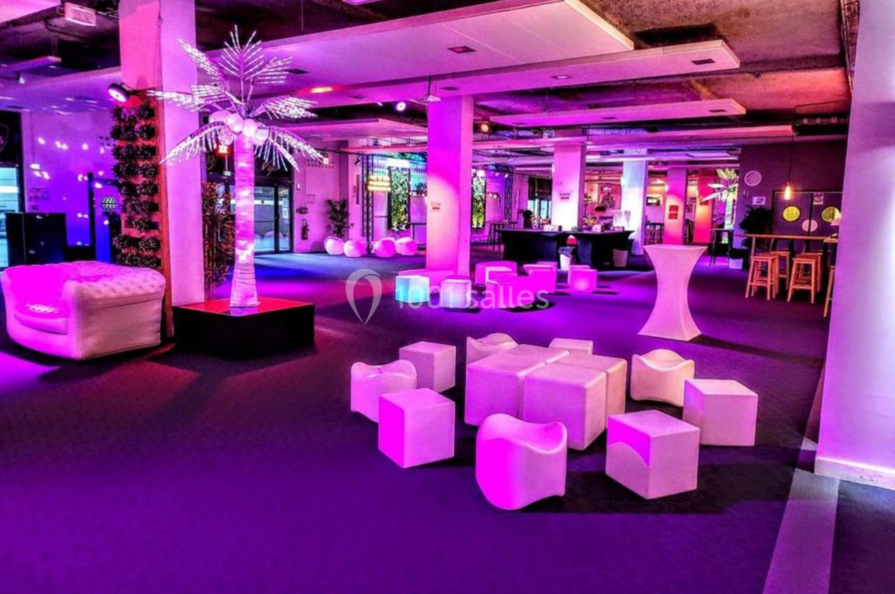 Espace intérieur moderne avec éclairage coloré, mobilier design blanc et ambiance festive.