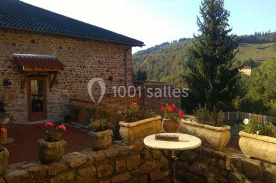 Structure en bois avec décorations de mariage, incluant des lettres blanches, un tonneau et des fleurs suspendues.