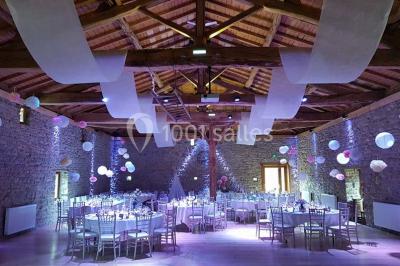 Structure en bois avec décorations de mariage, incluant des lettres blanches, un tonneau et des fleurs suspendues.