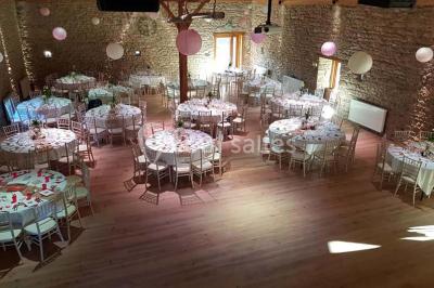 Structure en bois avec décorations de mariage, incluant des lettres blanches, un tonneau et des fleurs suspendues.