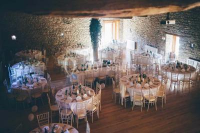 Structure en bois avec décorations de mariage, incluant des lettres blanches, un tonneau et des fleurs suspendues.