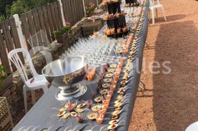 Structure en bois avec décorations de mariage, incluant des lettres blanches, un tonneau et des fleurs suspendues.