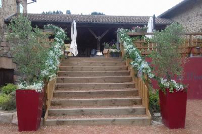 Structure en bois avec décorations de mariage, incluant des lettres blanches, un tonneau et des fleurs suspendues.