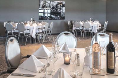 Une femme échange avec une réceptionniste dans le hall lumineux d'un hôtel, avec un coin salon visible en arrière-plan.