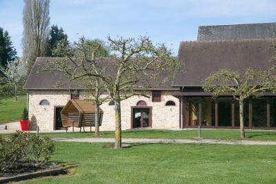 Vue aérienne d'un domaine avec bâtiments, allées, jardins et espaces verts entourés d'arbres.