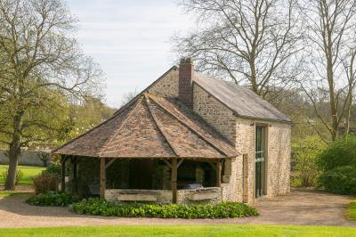 Vue aérienne d'un domaine avec bâtiments, allées, jardins et espaces verts entourés d'arbres.