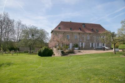 Vue aérienne d'un domaine avec bâtiments, allées, jardins et espaces verts entourés d'arbres.