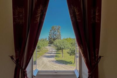 Vue aérienne d'un domaine avec bâtiments, allées, jardins et espaces verts entourés d'arbres.