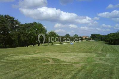 Vue aérienne d'un domaine entouré de forêts et de champs au coucher du soleil, avec des bâtiments et des allées visibles.