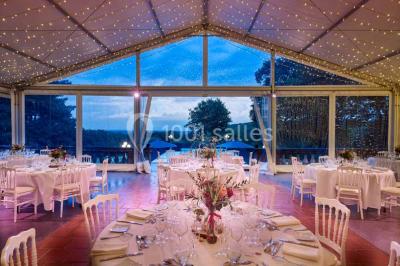 Vue aérienne d'un domaine entouré de forêts et de champs au coucher du soleil, avec des bâtiments et des allées visibles.