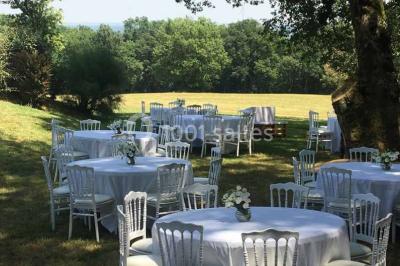 Vue aérienne d'un domaine entouré de forêts et de champs au coucher du soleil, avec des bâtiments et des allées visibles.