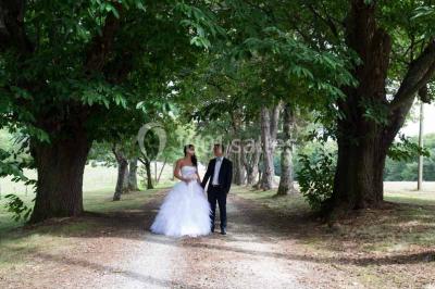 Vue aérienne d'un domaine entouré de forêts et de champs au coucher du soleil, avec des bâtiments et des allées visibles.
