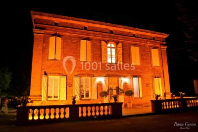 Vue aérienne d'un domaine entouré de forêts et de champs au coucher du soleil, avec des bâtiments et des allées visibles.