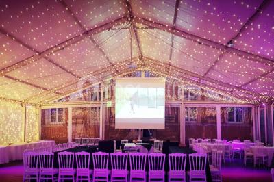 Vue aérienne d'un domaine entouré de forêts et de champs au coucher du soleil, avec des bâtiments et des allées visibles.