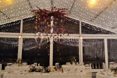 Vue aérienne d'un domaine entouré de forêts et de champs au coucher du soleil, avec des bâtiments et des allées visibles.