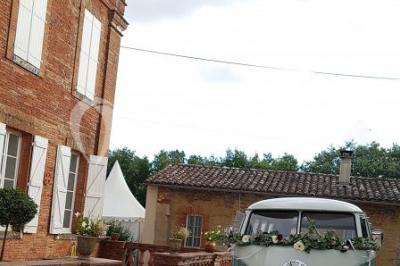 Vue aérienne d'un domaine entouré de forêts et de champs au coucher du soleil, avec des bâtiments et des allées visibles.