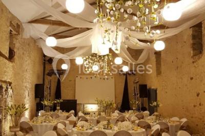 Chemin en gravier menant à des chalets en bois entourés de pelouse et d'arbres sous un ciel dégagé.