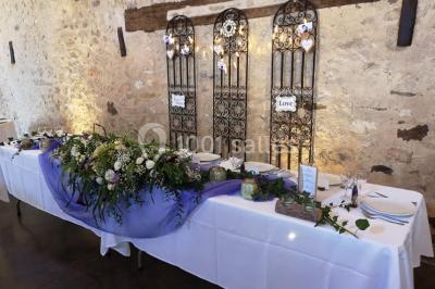 Chemin en gravier menant à des chalets en bois entourés de pelouse et d'arbres sous un ciel dégagé.