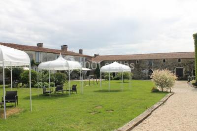 Chemin en gravier menant à des chalets en bois entourés de pelouse et d'arbres sous un ciel dégagé.
