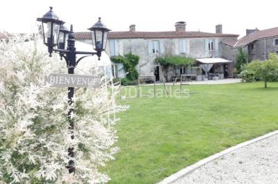 Chemin en gravier menant à des chalets en bois entourés de pelouse et d'arbres sous un ciel dégagé.