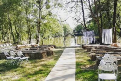 Chemin en gravier menant à des chalets en bois entourés de pelouse et d'arbres sous un ciel dégagé.
