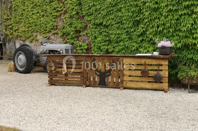 Chemin en gravier menant à des chalets en bois entourés de pelouse et d'arbres sous un ciel dégagé.