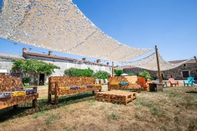 Chemin en gravier menant à des chalets en bois entourés de pelouse et d'arbres sous un ciel dégagé.