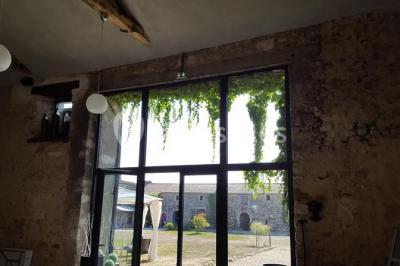 Salle de réception décorée avec des tables dressées, nappes blanches, chaises pliantes et centres de table fleuris.