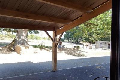 Salle de réception décorée avec des tables dressées, nappes blanches, chaises pliantes et centres de table fleuris.