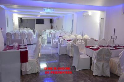 Assiette contenant du riz, du poulet grillé, des bananes plantains frites, des légumes sautés et des sauces en…