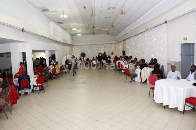 Assiette contenant du riz, poulet grillé, bananes plantains frites, légumes sautés et sauces en accompagnement.