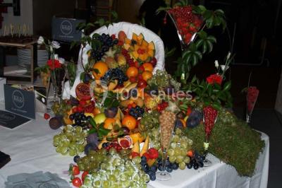 Grande jarre en terre cuite posée dans un jardin verdoyant entouré de plantes et d'arbres.