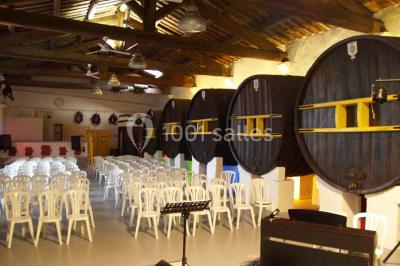 Grande jarre en terre cuite posée dans un jardin verdoyant entouré de plantes et d'arbres.