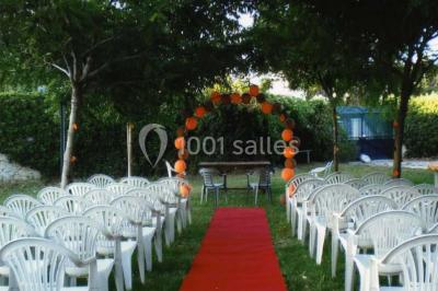 Grande jarre en terre cuite posée dans un jardin verdoyant entouré de plantes et d'arbres.