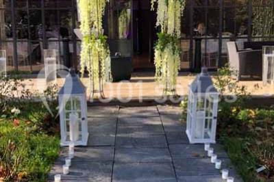 Miniature Location salle Préaux-Bocage (Calvados) - Domaine d'Aslan #13 Paysage rural avec un chemin en gravier, des champs de colza jaunes, des arbres et une terrasse en pierre au premier plan.