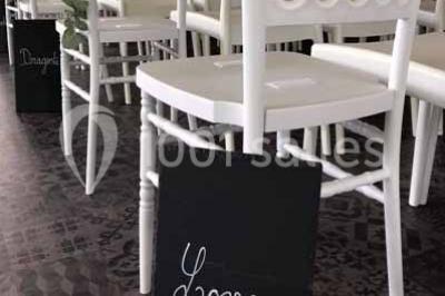 Miniature Location salle Préaux-Bocage (Calvados) - Domaine d'Aslan #19 Paysage rural avec un chemin en gravier, des champs de colza jaunes, des arbres et une terrasse en pierre au premier plan.