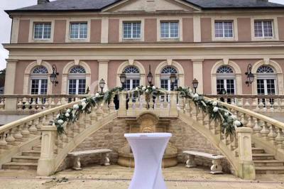 Miniature Location salle Préaux-Bocage (Calvados) - Domaine d'Aslan #14 Paysage rural avec un chemin en gravier, des champs de colza jaunes, des arbres et une terrasse en pierre au premier plan.