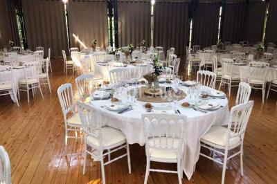 Miniature Location salle Préaux-Bocage (Calvados) - Domaine d'Aslan #5 Paysage rural avec un chemin en gravier, des champs de colza jaunes, des arbres et une terrasse en pierre au premier plan.