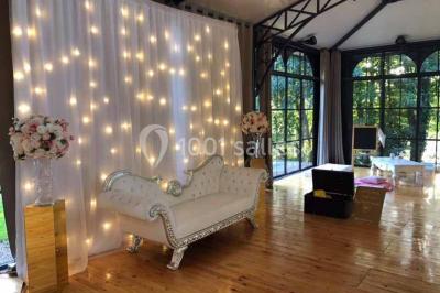 Miniature Location salle Préaux-Bocage (Calvados) - Domaine d'Aslan #15 Paysage rural avec un chemin en gravier, des champs de colza jaunes, des arbres et une terrasse en pierre au premier plan.