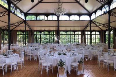 Miniature Location salle Préaux-Bocage (Calvados) - Domaine d'Aslan #2 Paysage rural avec un chemin en gravier, des champs de colza jaunes, des arbres et une terrasse en pierre au premier plan.