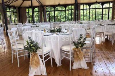 Miniature Location salle Préaux-Bocage (Calvados) - Domaine d'Aslan #3 Paysage rural avec un chemin en gravier, des champs de colza jaunes, des arbres et une terrasse en pierre au premier plan.