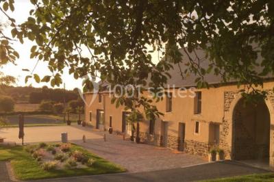 Centre de table floral avec fleurs séchées et pampas, entouré de couverts et cadeaux emballés sur une nappe blanche.