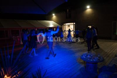 Centre de table floral avec fleurs séchées et pampas, entouré de couverts et cadeaux emballés sur une nappe blanche.