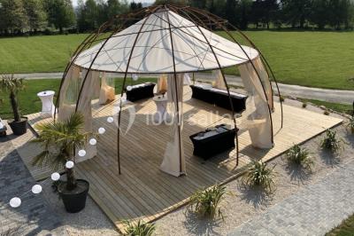 Centre de table floral avec fleurs séchées et pampas, entouré de couverts et cadeaux emballés sur une nappe blanche.