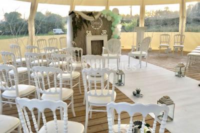 Centre de table floral avec fleurs séchées et pampas, entouré de couverts et cadeaux emballés sur une nappe blanche.