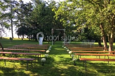 Centre de table floral avec fleurs séchées et pampas, entouré de couverts et cadeaux emballés sur une nappe blanche.